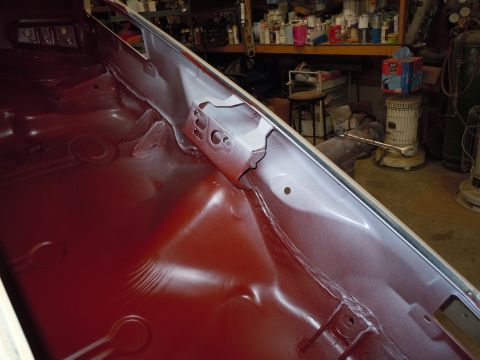 1973 Pontiac Trans Am - Car interior floor pan with red paint applied, revealing structural components and some unfinished areas.