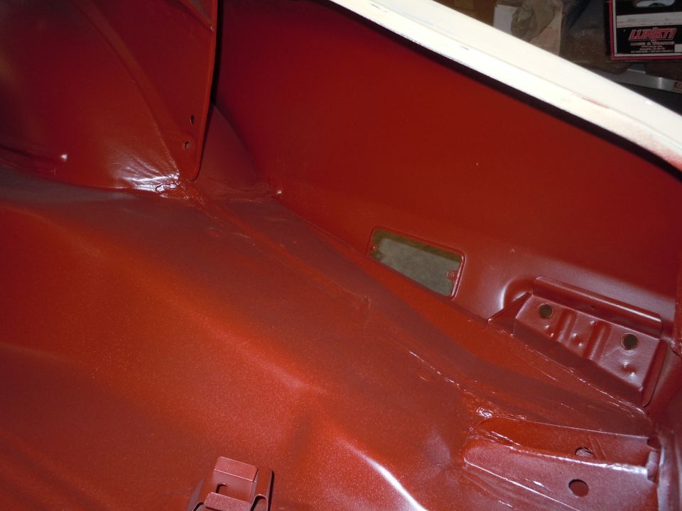 Red painted car interior showing metal seams and a rectangular cutout