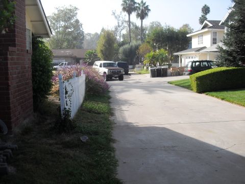 1986 Ford Bronco - A white Ford Bronco with a brown top is parked on a suburban driveway.