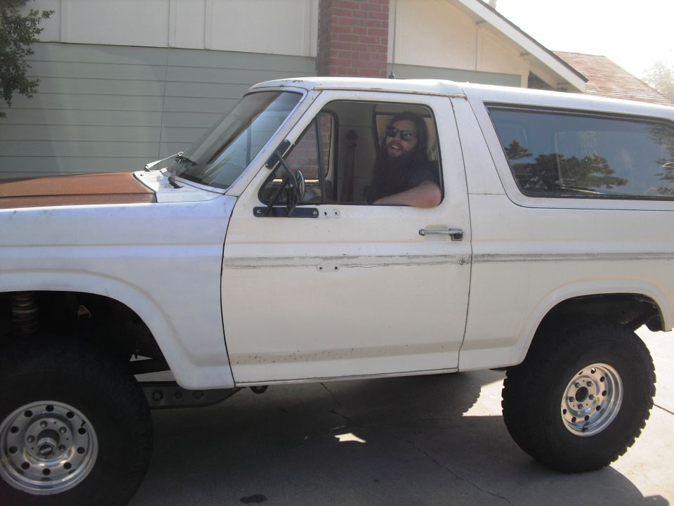 1986 Ford Bronco side view with a man in the driver's seat