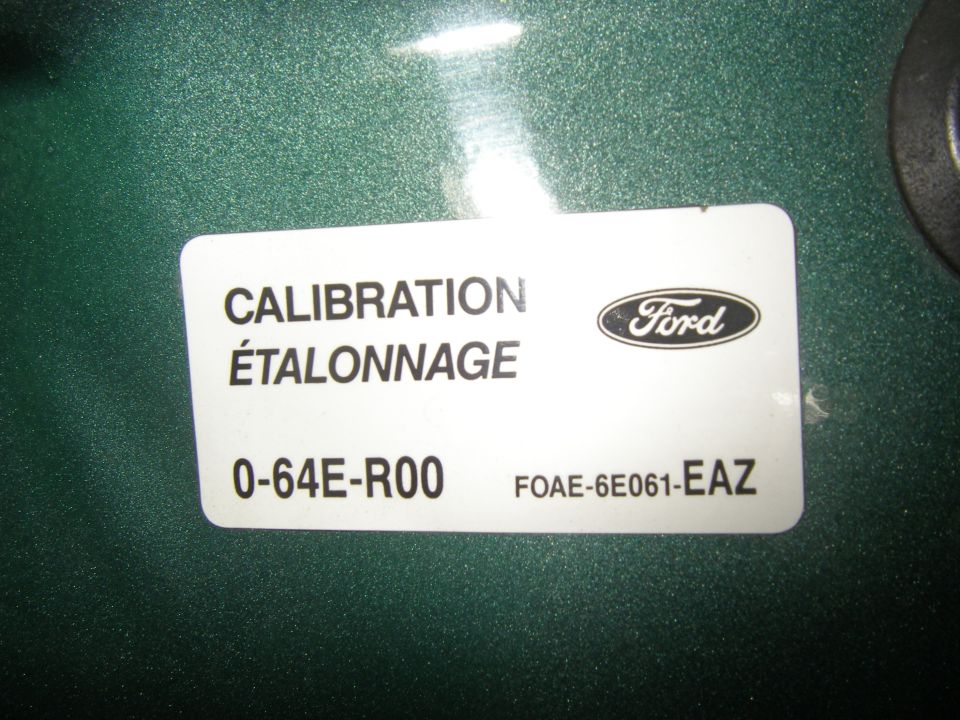Ford calibration label 0-64E-R00 F0AE-6E061-EAZ on green surface