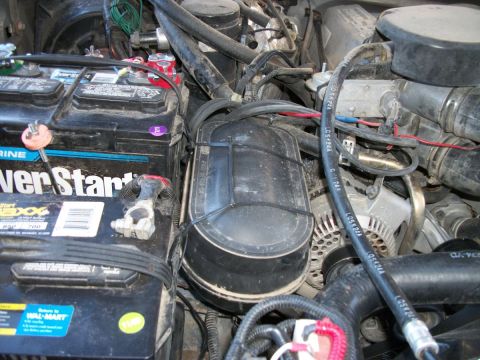 1996 Ford Bronco - Close-up view of a vehicle's engine bay, focusing on the battery and air intake system.
