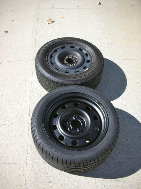 2004 Ford Crown Victoria - Two spare tires, one Goodyear Eagle and one Continental, sit on a concrete surface.