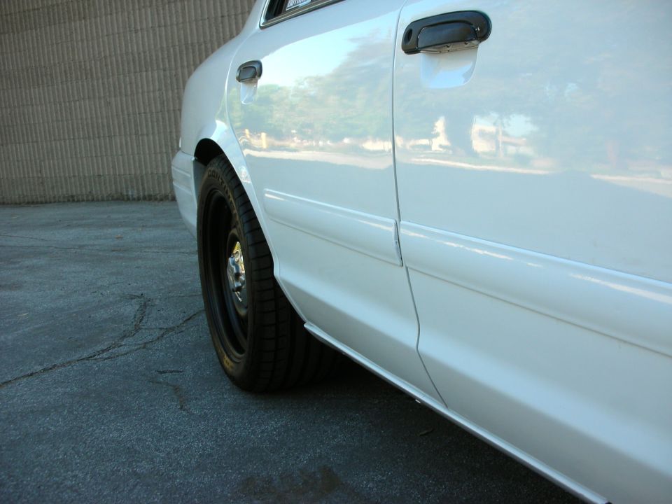 White 2004 Ford Crown Victoria side view with black wheels