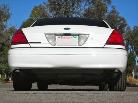 2004 Ford Crown Victoria - Rear view of a white 2004 Ford Crown Victoria, displaying its taillights, license plate, and dual exhaust system.