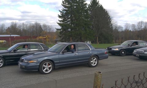 2007 Ford Crown Victoria - A blue 2007 Ford Crown Victoria is parked with two other sedans in a lot.