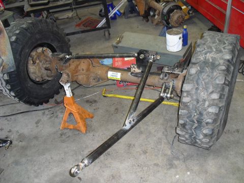1986 Ford Bronco - Close-up of vehicle axle and suspension components, possibly during a repair or modification.