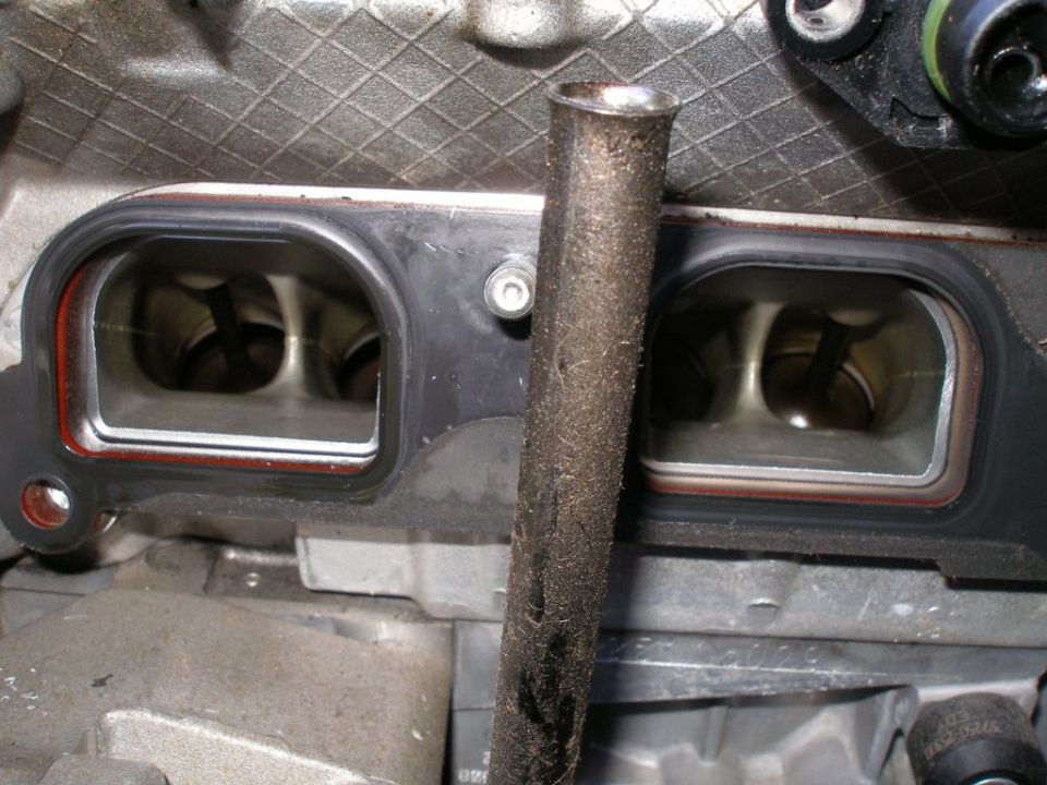 Engine intake ports with gasket, metal tube, and Supermotors.net logo