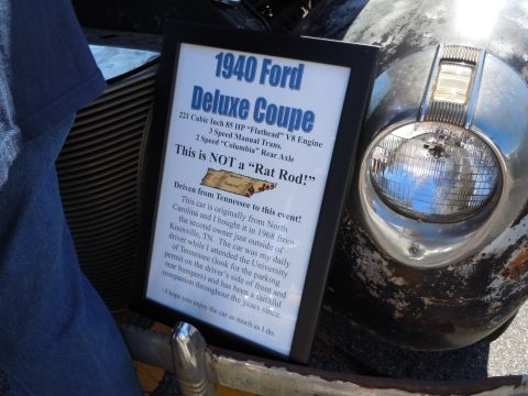 1979 Chevrolet Camaro - A sign details the history and specifications of a 1940 Ford Deluxe Coupe, displayed next to the vehicle.
