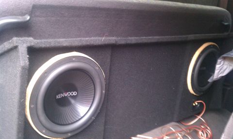 1978 Ford Bronco - Close-up of aftermarket subwoofers installed in a vehicle's cargo area.