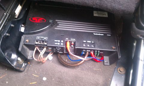 1978 Ford Bronco - A Rockford Fosgate car amplifier is visible, wired and installed beneath a vehicle seat.