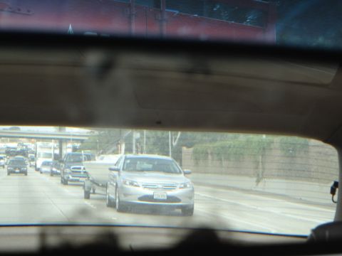 1993 Ford Taurus - A silver sedan is seen towing a boat while driving on a highway with other vehicles around.