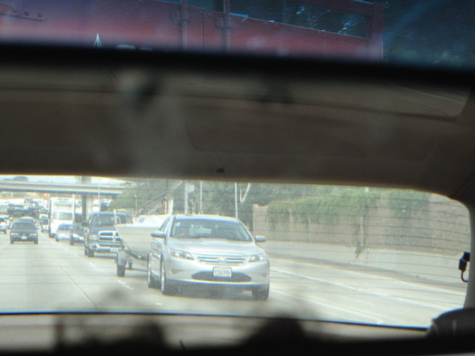 Silver sedan towing a boat on the highway