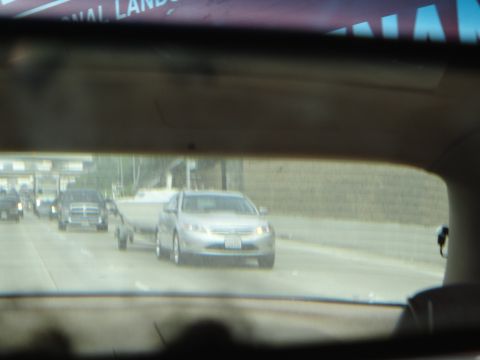 1993 Ford Taurus - A silver sedan tows a boat trailer on a highway, with other vehicles visible in traffic.