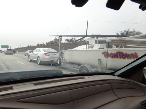 1993 Ford Taurus - A silver sedan, likely a Ford Taurus from the 2010s, tows a boat trailer with 'ToonTown' written on its side.