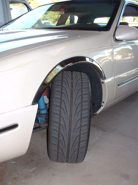 1997 Mercury Cougar - Close-up of a car's front tire and suspension system, showing the wheel well and part of the fender.