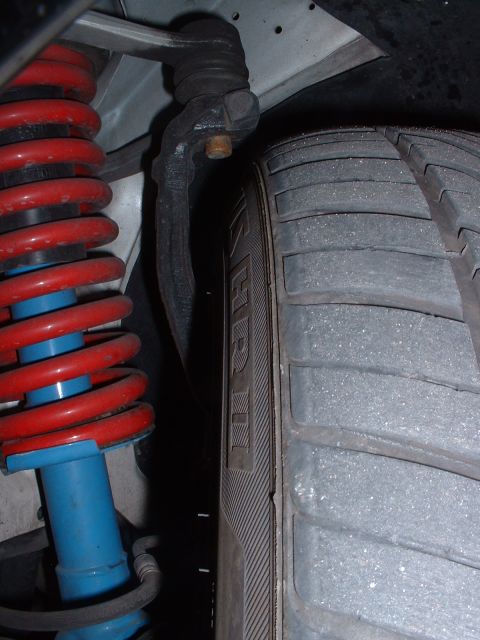 1997 Mercury Cougar - This image shows a close-up view of a vehicle's suspension system, including a tire and shock absorber.