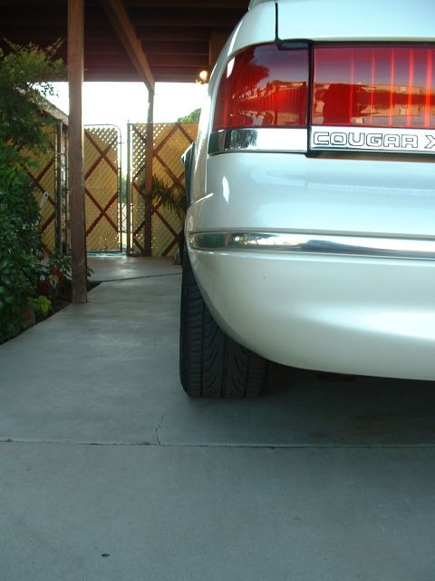 1997 Mercury Cougar - The rear of a white 1997 Mercury Cougar is shown, with a 'COUGAR X' badge visible on the trunk lid.