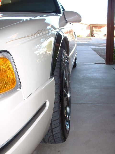 1997 Mercury Cougar - Side profile of a white car, focusing on the wheel and fender area.