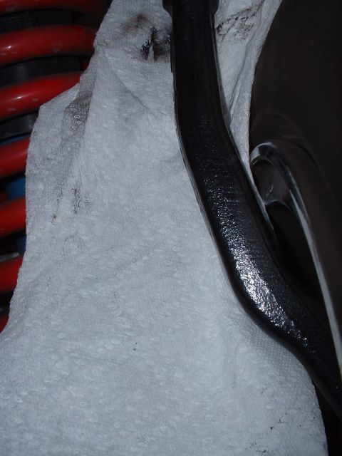 1997 Mercury Cougar - Close-up view of a black suspension component next to a red coil spring.