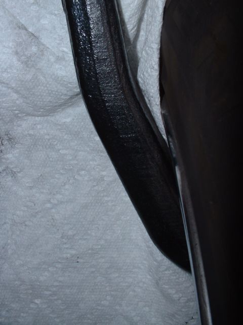 1997 Mercury Cougar - Close-up of a black suspension part, likely from a vehicle, placed on paper towels.