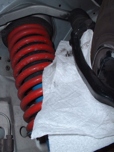 1997 Mercury Cougar - A close-up view of a vehicle's suspension system, focusing on the coil spring and associated components.