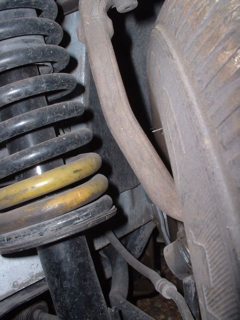 1997 Mercury Cougar - Detail of a vehicle's suspension components, including a shock absorber and spring.