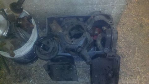 1988 Ford Bronco - Various rusty solid axle components are piled together on the ground.