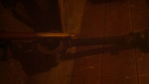1988 Ford Bronco - Vehicle axle assembly shown in detail against a wooden plank background.