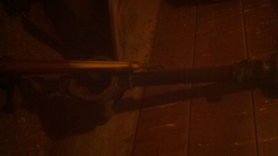 Close-up of a vehicle's rear axle assembly on a wooden floor