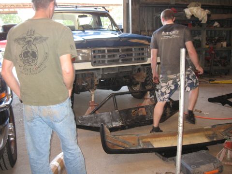 1994 Ford Bronco - A Ford truck is in a garage with its front bumper removed and is supported by jack stands.