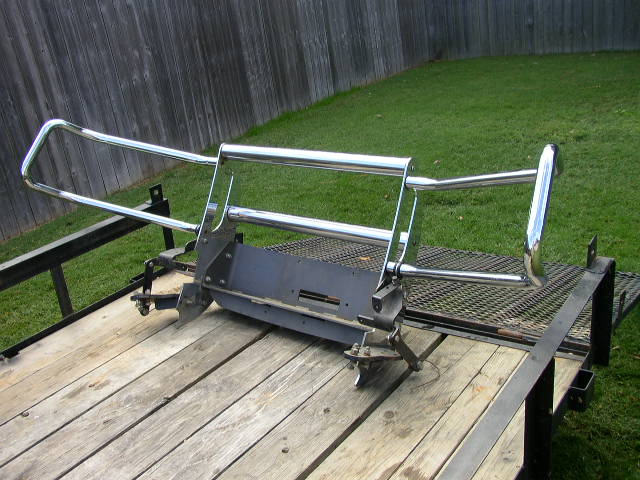 Chrome tubular truck grille guard with mounting frame sitting on a wooden trailer deck