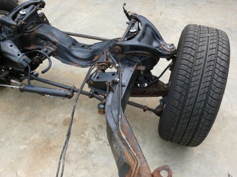1976 Chevrolet Corvette - The chassis and suspension components of a car are visible, with a single tire attached.
