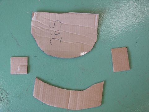 1976 Chevrolet Corvette - Cardboard cutouts with handwritten numbers are laid out on a green surface.
