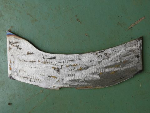 1976 Chevrolet Corvette - This is a metal fragment with visible grind marks, not a 1976 Chevrolet Corvette.