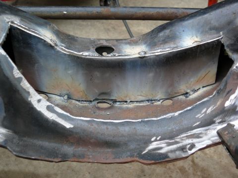 1976 Chevrolet Corvette - This image shows a close-up view of a vehicle's frame, highlighting recent welding work and several circular openings.