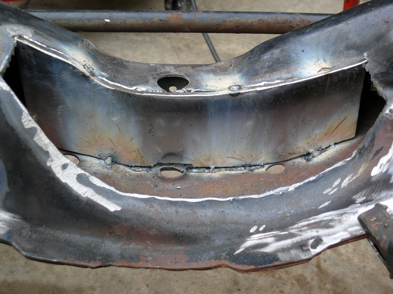 Close-up of a metal frame section with visible welds and holes. A 'SUPERMOTORS' logo is in the bottom right corner