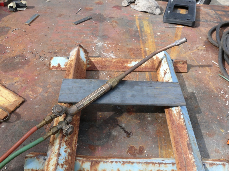 oxy-acetylene cutting torch on a rusty metal surface