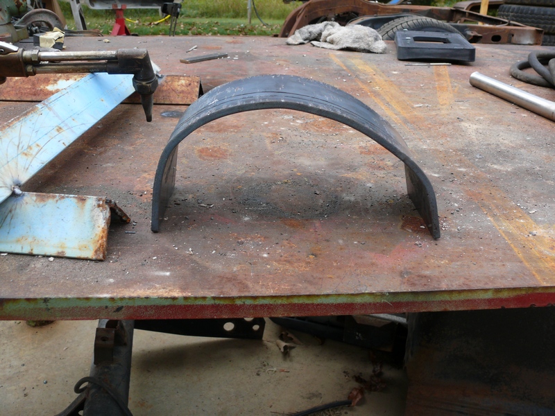 Metal fender flare on a rusty workbench with a cutting torch