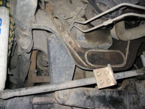 1986 Ford Bronco - Close-up view of the undercarriage, showing suspension parts and a bolted metal bracket.