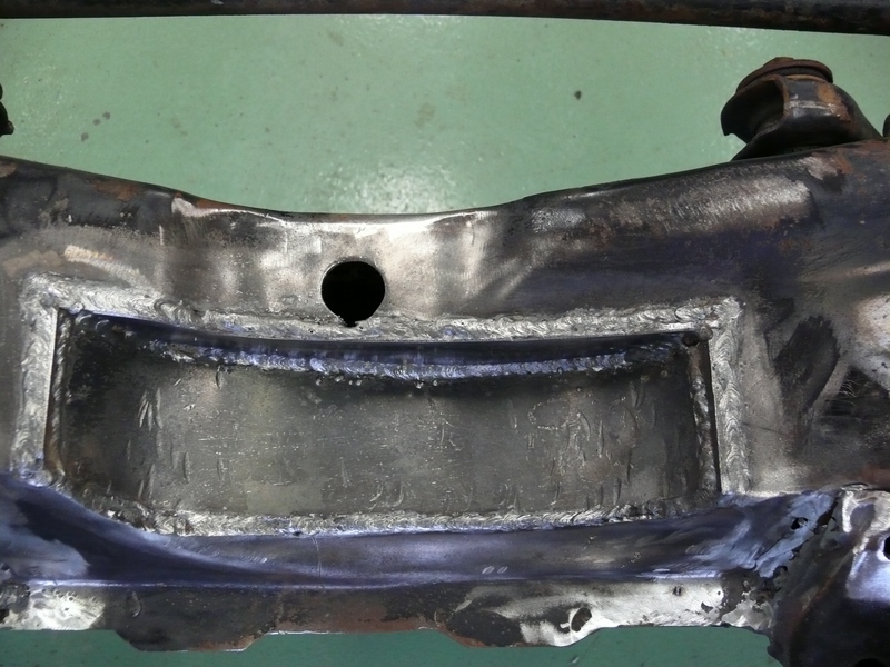 Close-up of a welded metal frame part with a hole in it