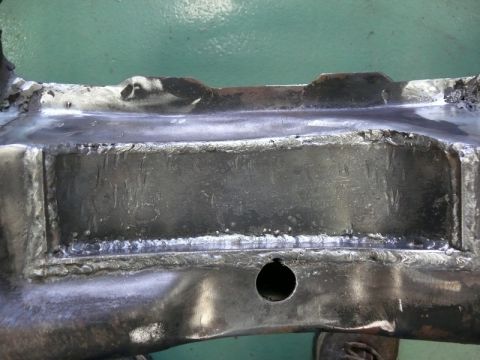 1976 Chevrolet Corvette - Close-up of a welded frame section, showing repairs and some stamped or etched text.