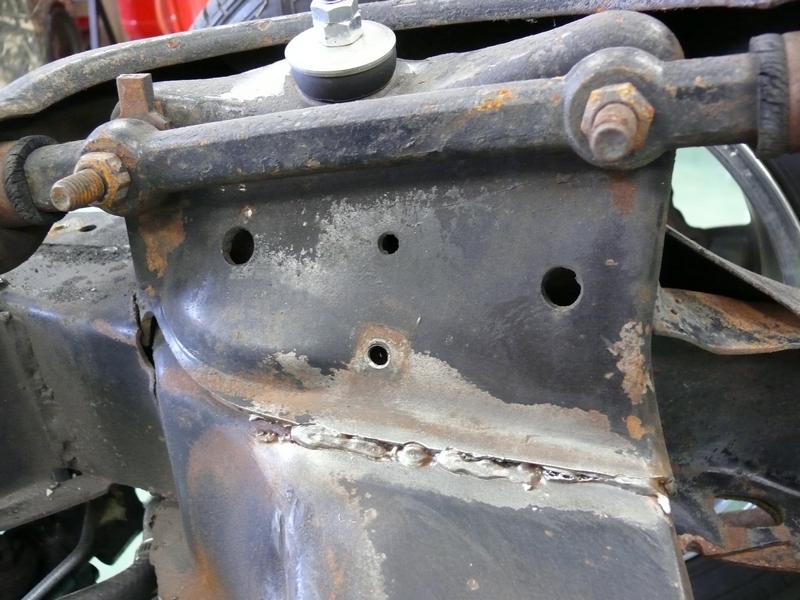 close-up of rusty car chassis with suspension parts and bolts