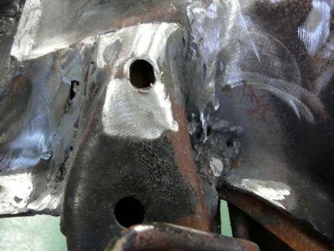 1976 Chevrolet Corvette - This image shows a close-up of a welded metal frame, likely a vehicle part, with visible holes and repair marks.