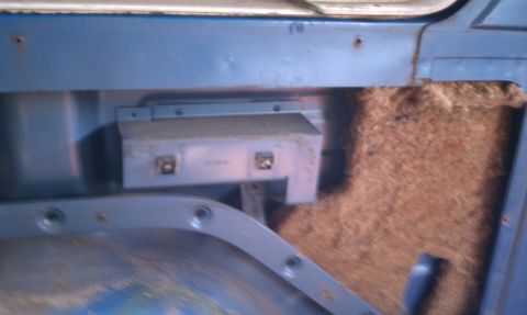 1979 Ford Bronco - Close-up of a vehicle's interior door panel, revealing insulation and a mounting bracket.