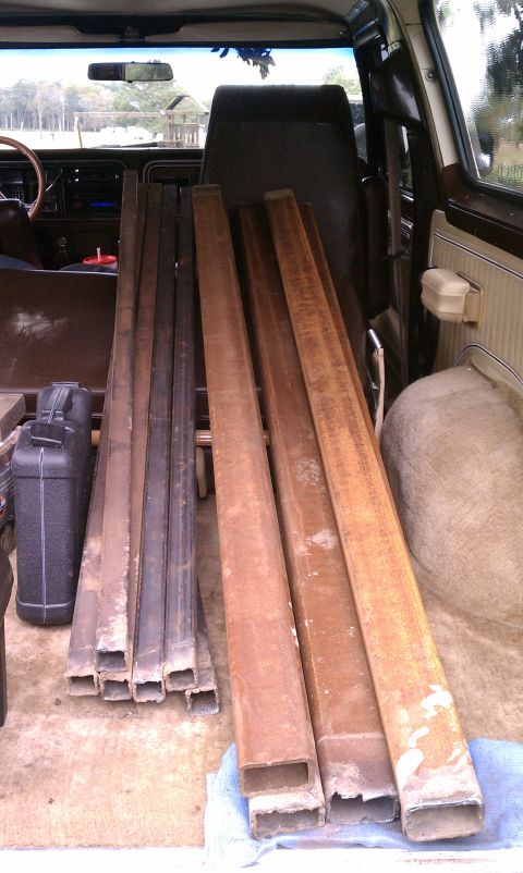 1979 Ford Bronco - Metal pipes fill the cargo area of a 1979 Ford Bronco, viewed from the interior.