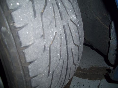 1995 Ford Probe - The tire tread shows significant wear, with some white specks scattered across its surface.
