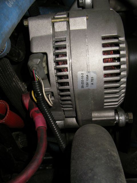 1990 Ford Bronco - Close-up of a vehicle alternator, showing part number and specifications.