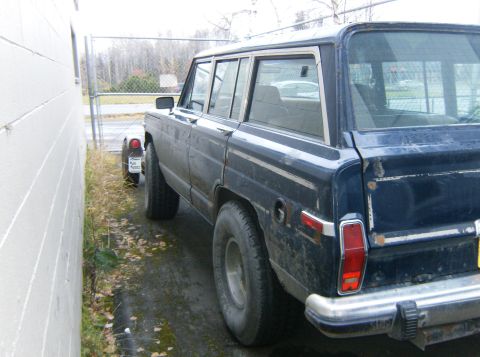 2000 Ford E350 - Station wagon parked next to a building, showing its side profile and rear quarter panel.