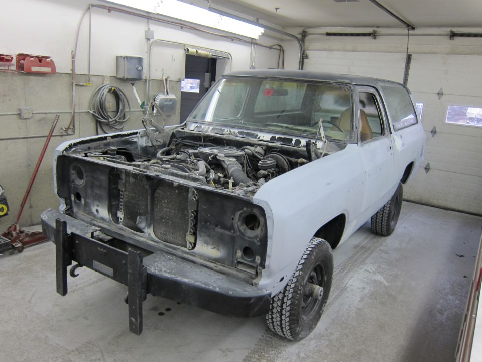 1987 Dodge Ramcharger with hood open, undergoing bodywork in a garage